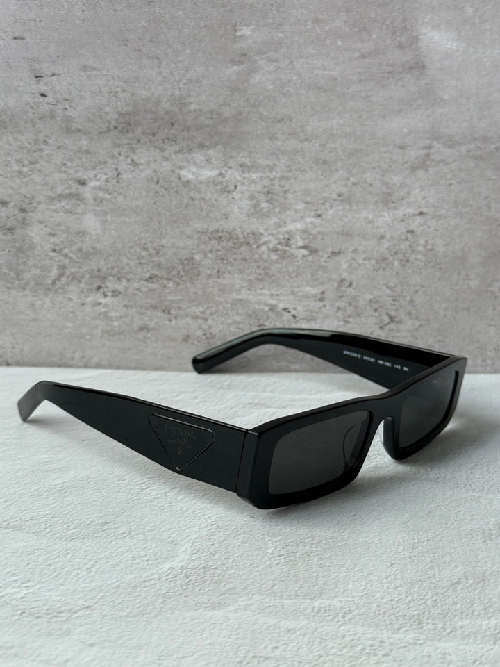 Prada black rectangular sunglasses with dark lenses, angled top view.