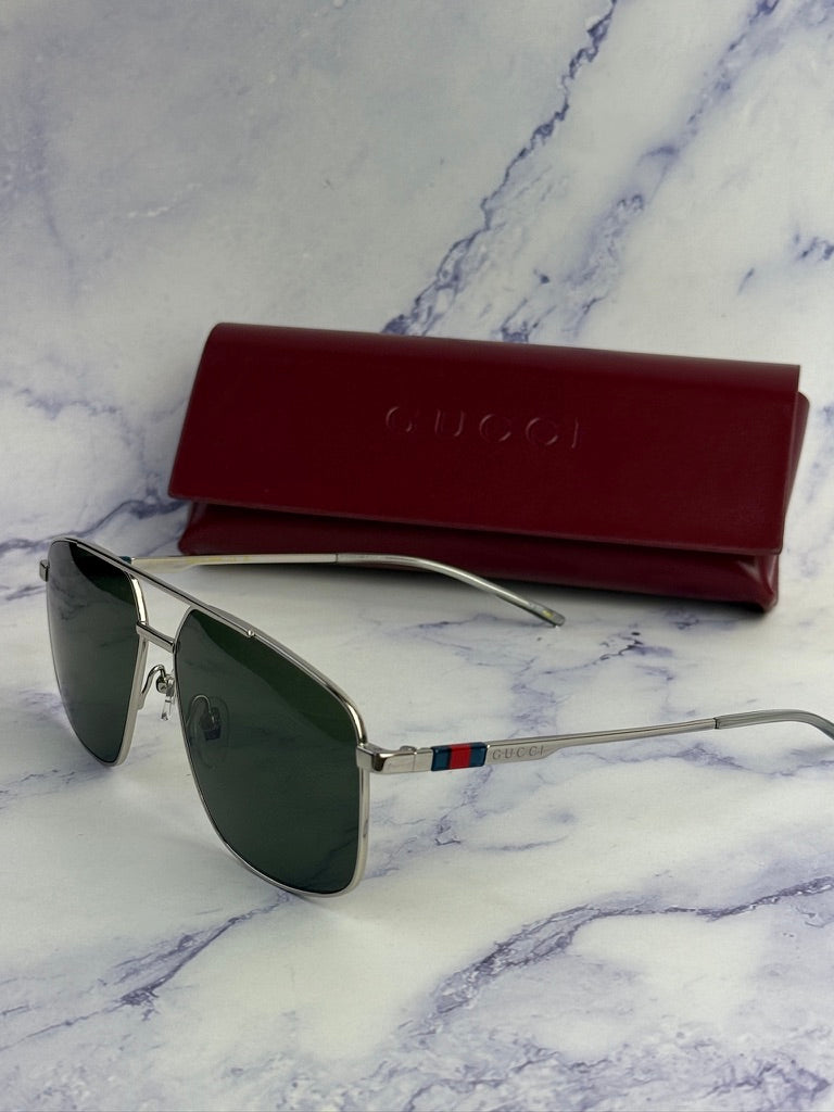 Silver metal aviator sunglasses with green lenses and red Gucci case