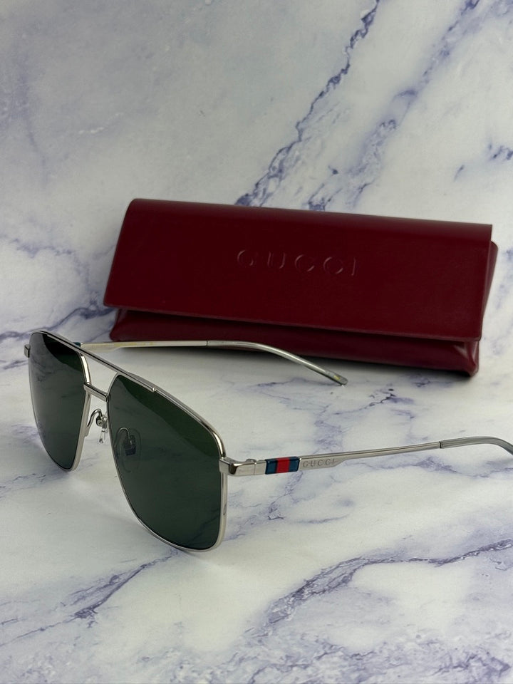 Silver metal aviator sunglasses with green lenses and red Gucci case