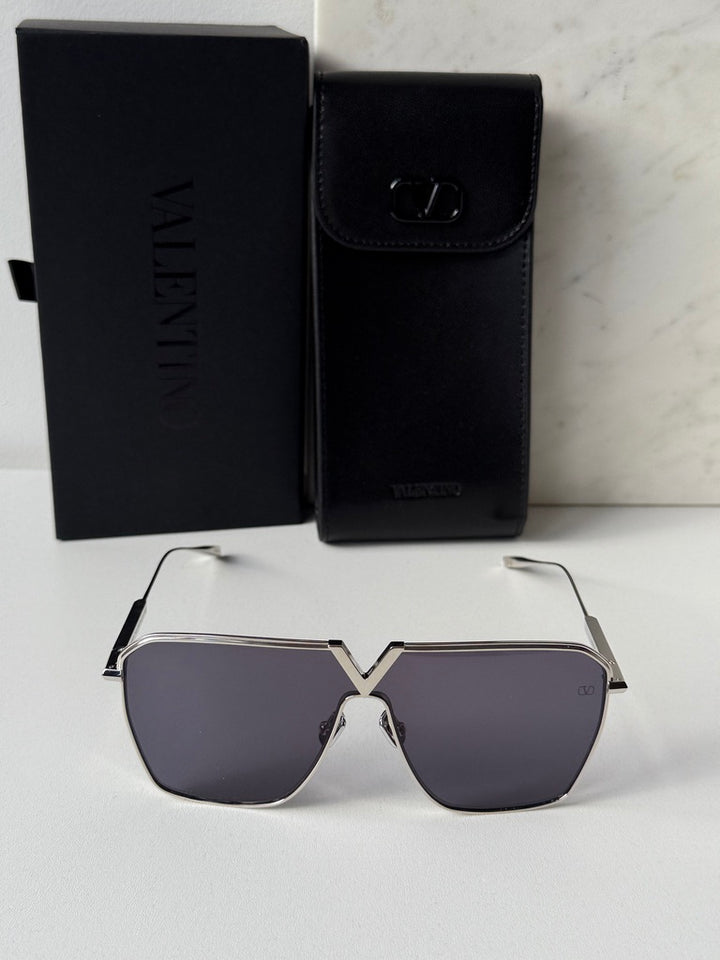 Silver aviator sunglasses with dark lenses, shown with black Valentino case