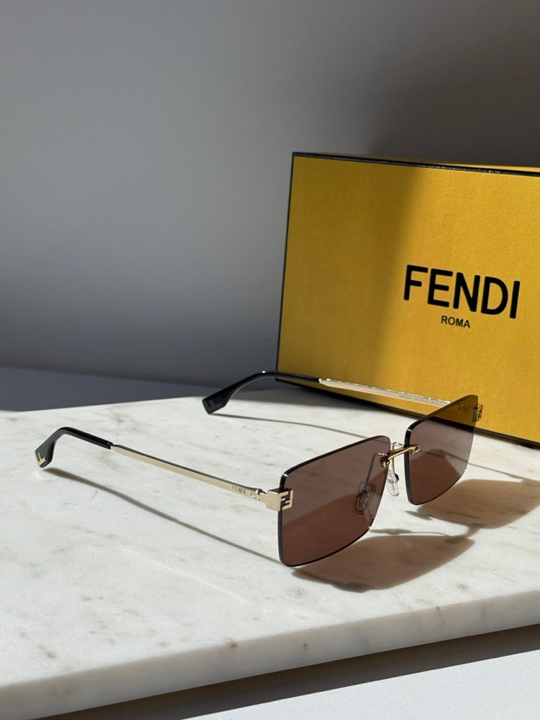 Rimless square sunglasses with brown tinted lenses and gold metal bridge, black temples