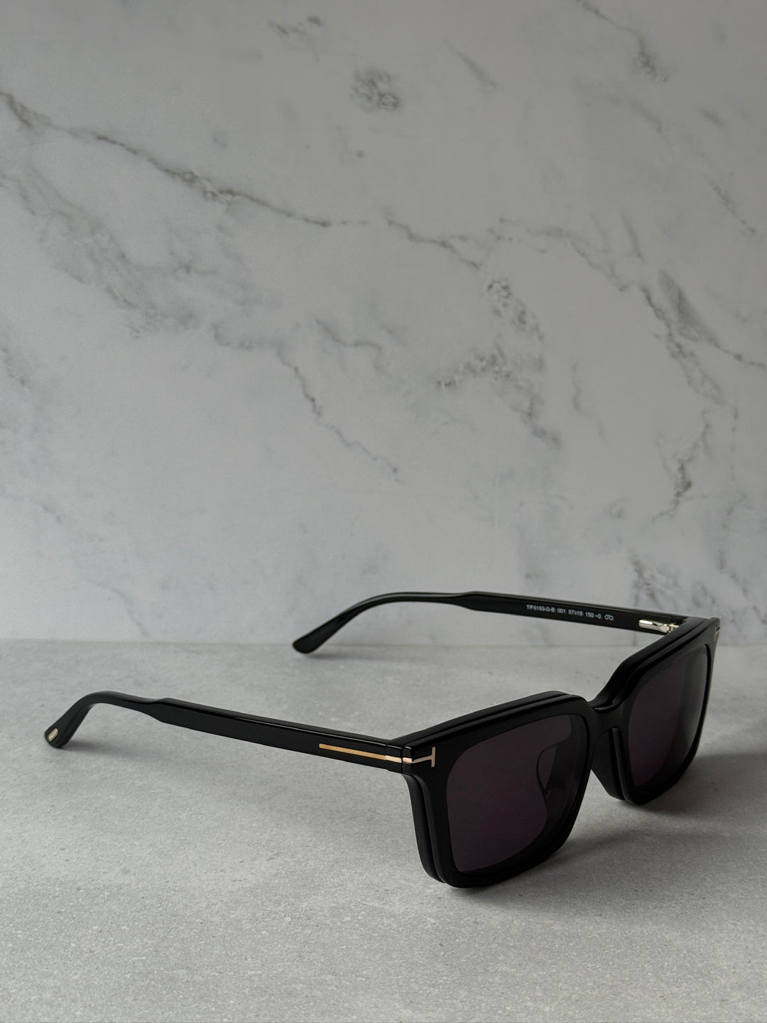 Black rectangular sunglasses angled view with purple-tinted dark lenses