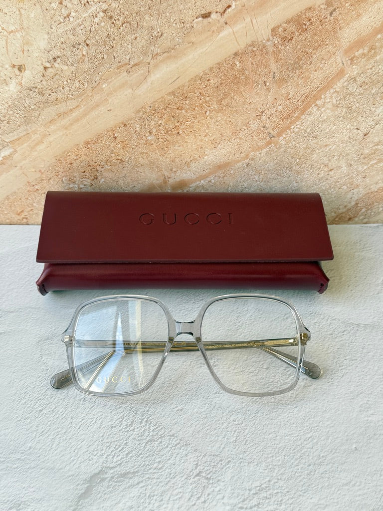 Gucci transparent grey eyeglass frames with gold-tone temples and case