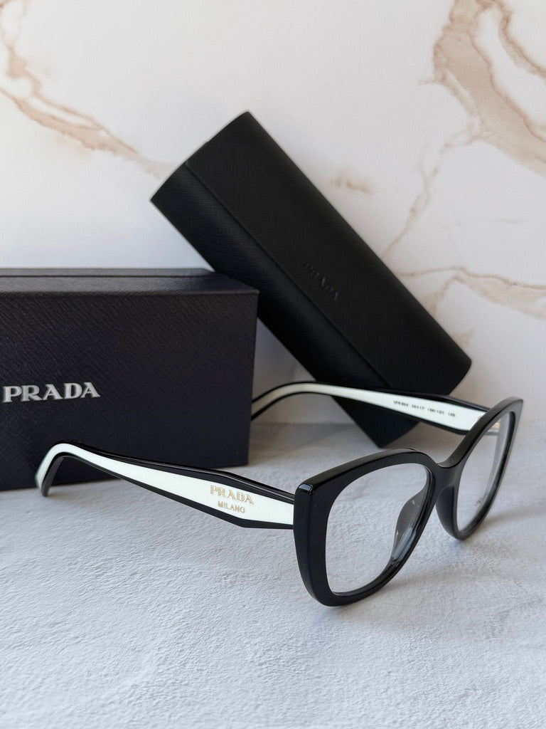 Black and white cat-eye eyeglasses frames with clear lenses, angled view.