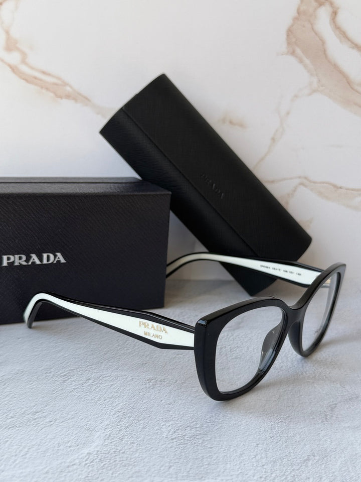 Black and white cat-eye eyeglasses frames with clear lenses, angled view.