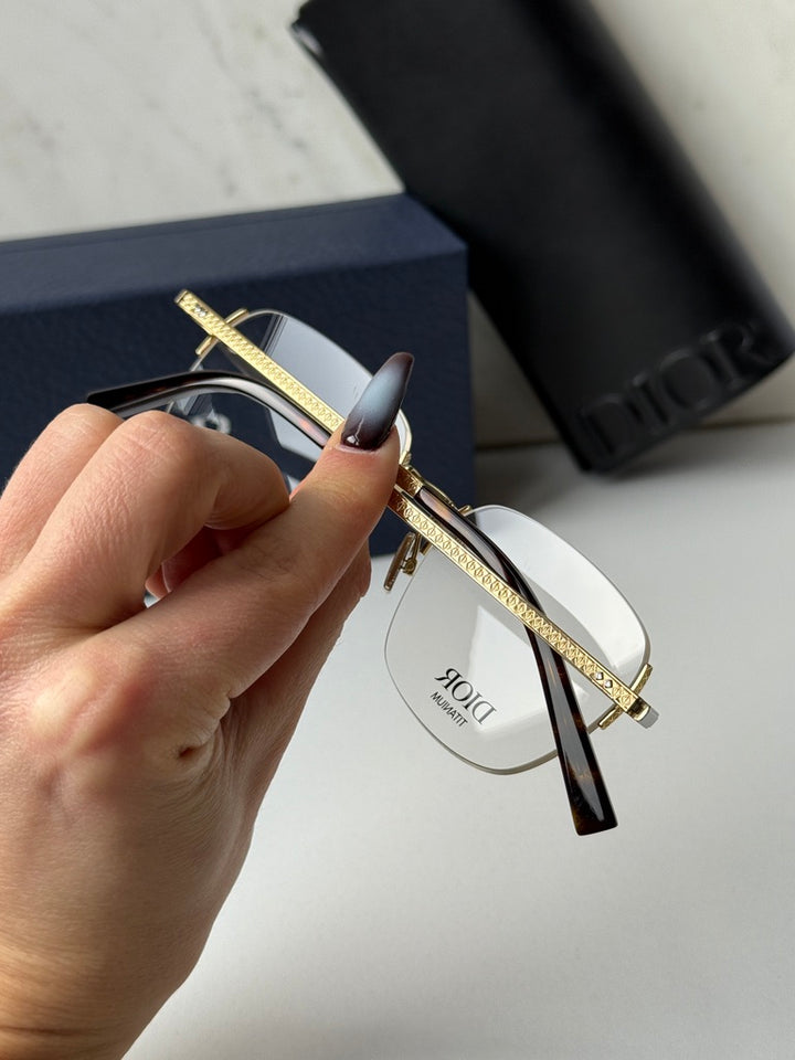 Two-tone metal DIOR rimless eyeglasses close-up with dark temple accent and clear lenses