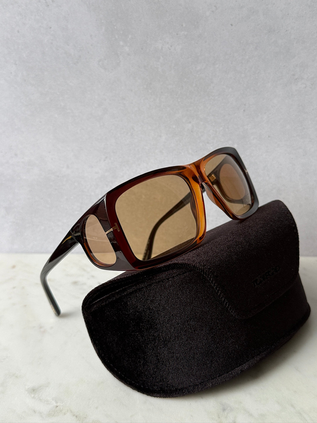 Brown tortoise sunglasses with amber lenses, shown with a black storage pouch
