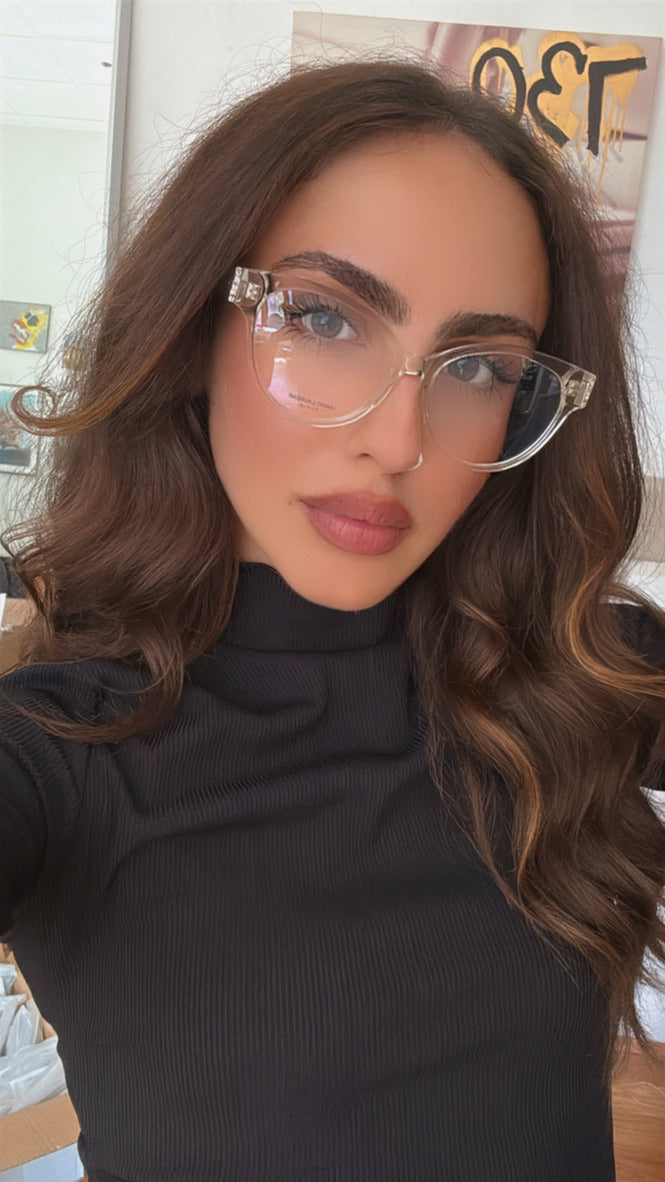 Woman wearing Saint Laurent clear cat-eye eyeglass frames with metal temples