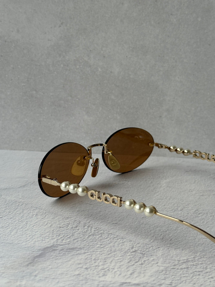 Gucci GG1257S Gafas de sol redondeadas con lentes marrones y rojos