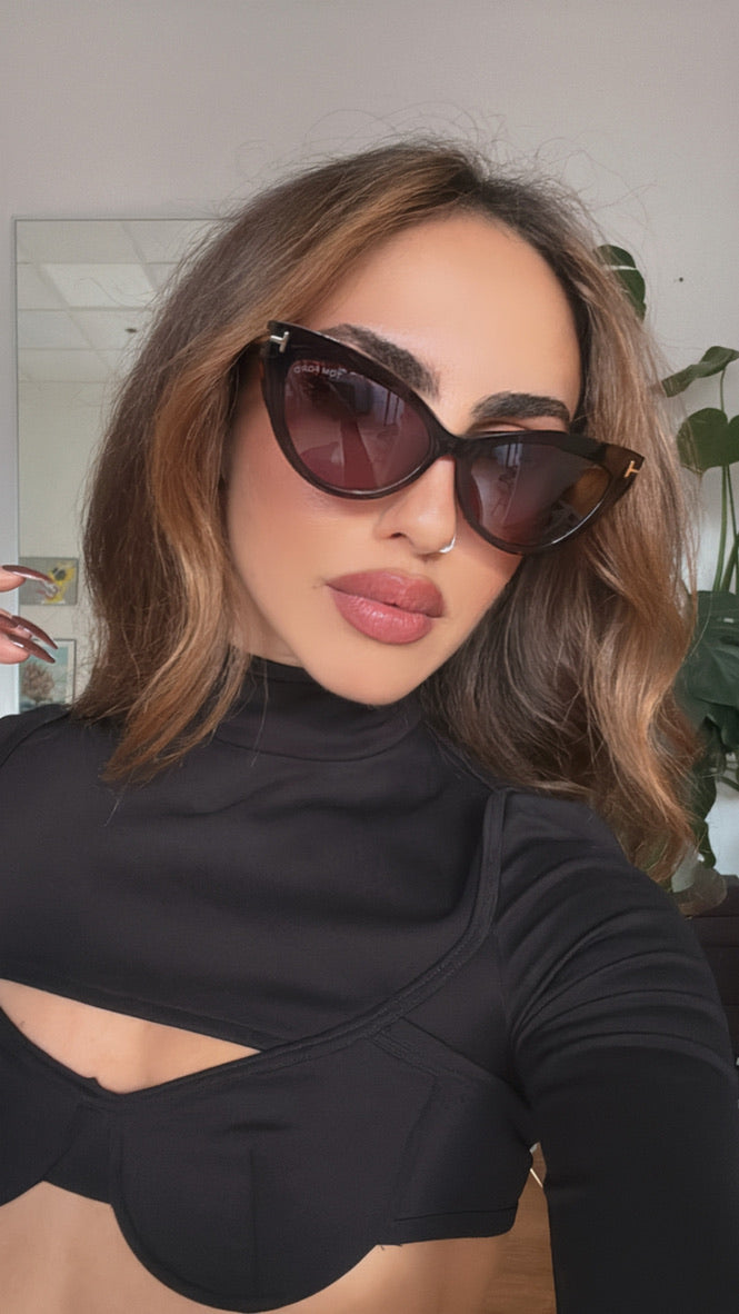 Cat-eye sunglasses on model, havana-brown frames with dark pink-tinted lenses