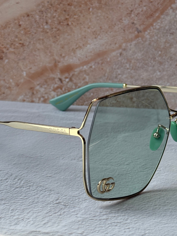 Gafas de sol cuadradas extragrandes de metal con lentes verdes Gucci GG0817S