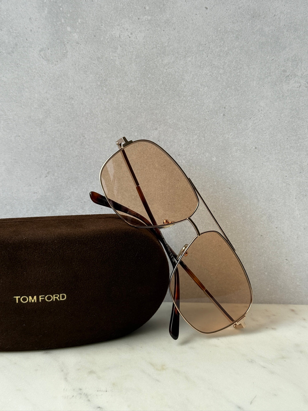 Gold photochromic oval sunglasses with brown-tinted lenses and slim metal frame
