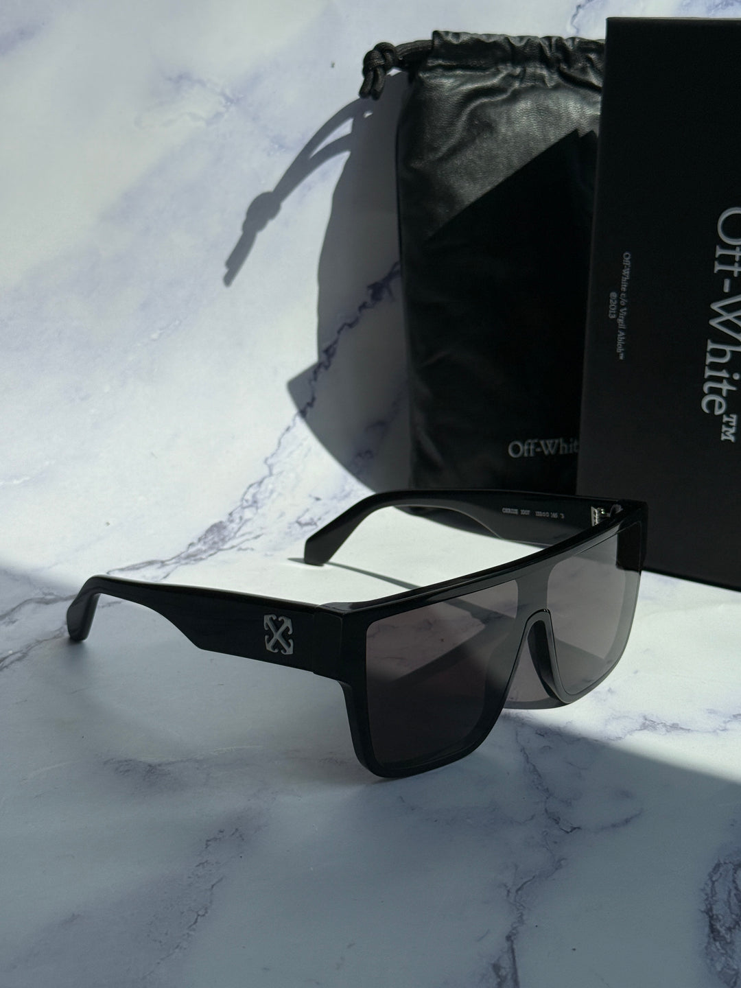 Black square sunglasses with dark lenses and included black protective pouch