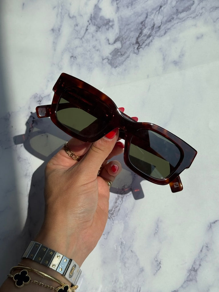 Tortoiseshell square sunglasses with green lenses, held in hand, FENDI logo