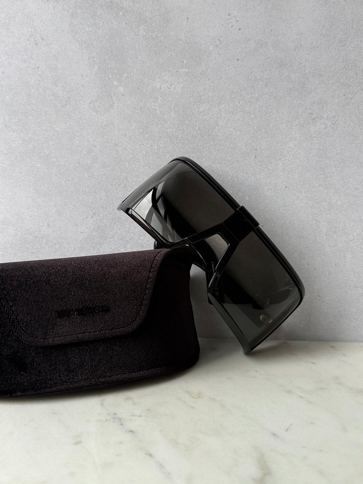 Black mask-style sunglasses with dark tinted lenses and black pouch