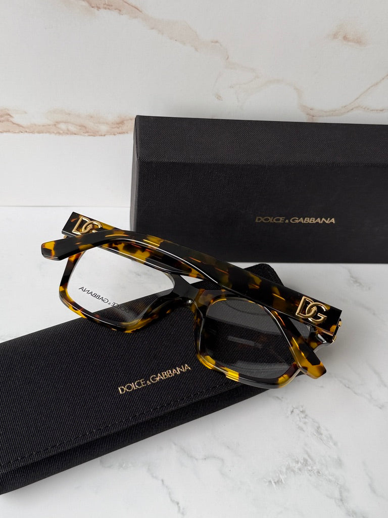 Tortoise-brown eyeglass frames with angular shape and gold DG logo accents