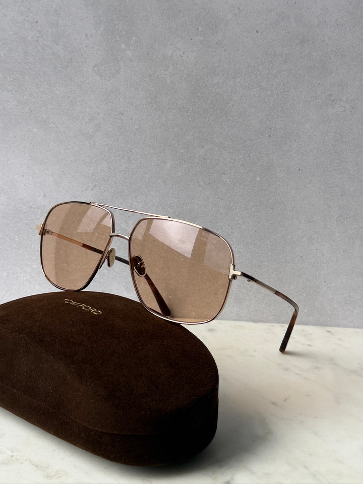 Gold photochromic sunglasses with tinted lenses, metal hinges, and slim arms