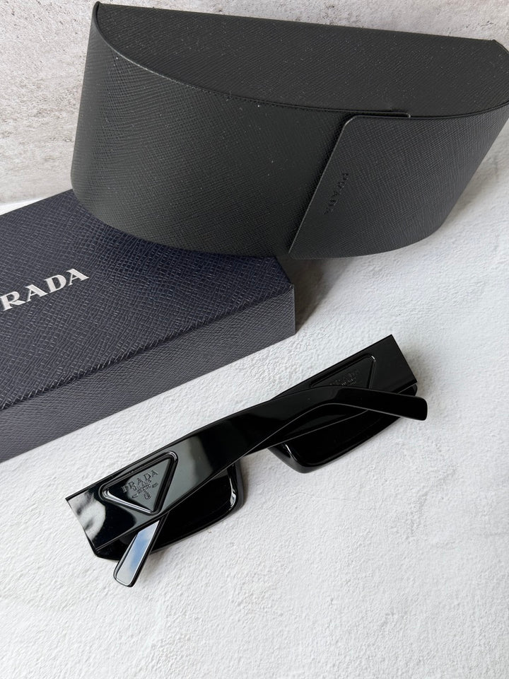 Prada black sunglasses with dark lenses and visible logo on the temple.