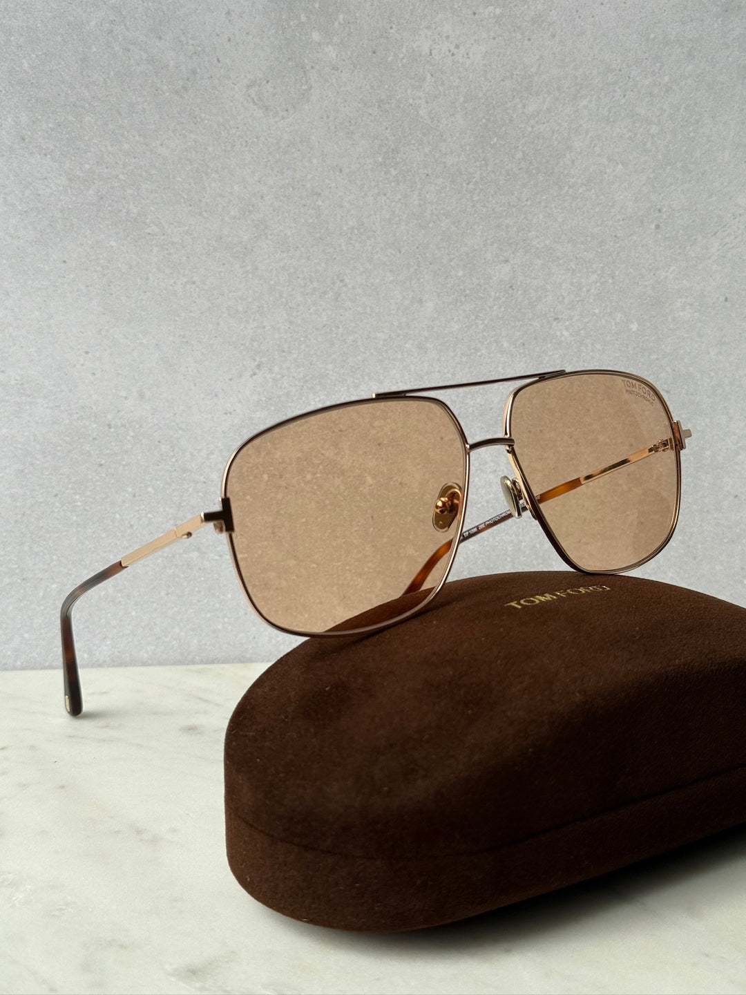 Gold photochromic oval sunglasses with tinted lenses and adjustable nose pads