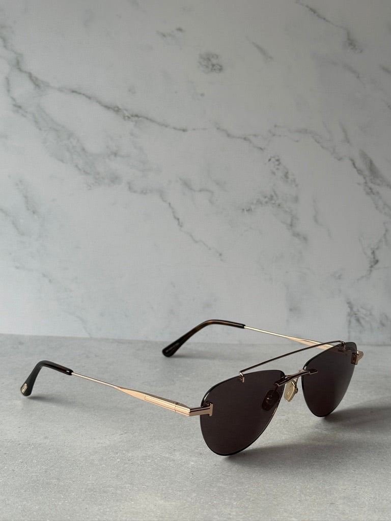 Rose gold aviator sunglasses with dark lenses and slim metal temples, side view