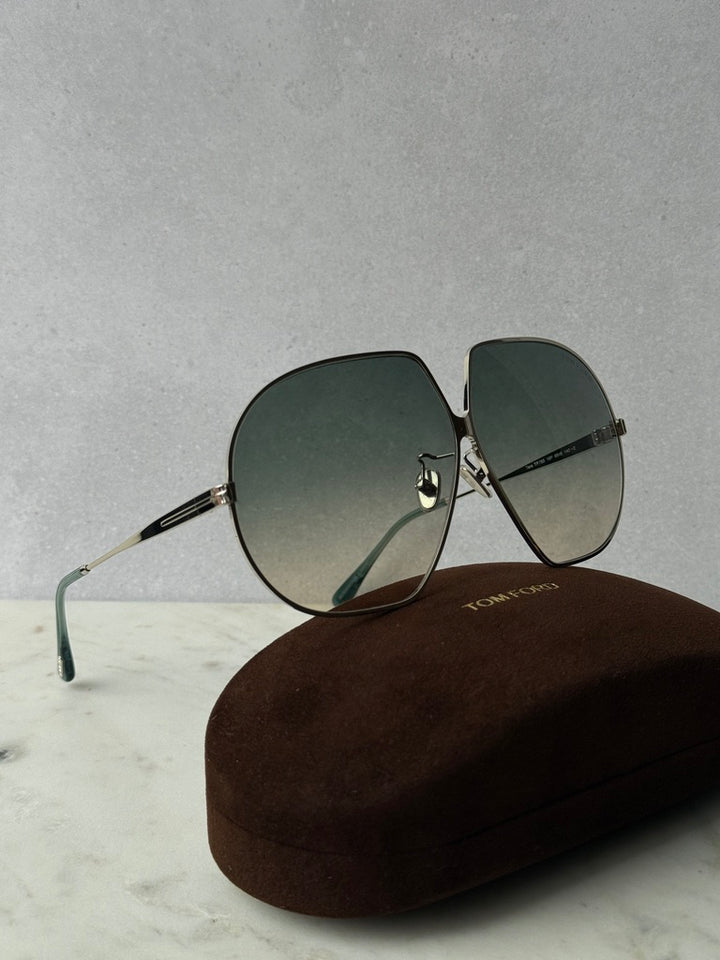 Oversized sunglasses with silver arms, dark green lenses, and protective case