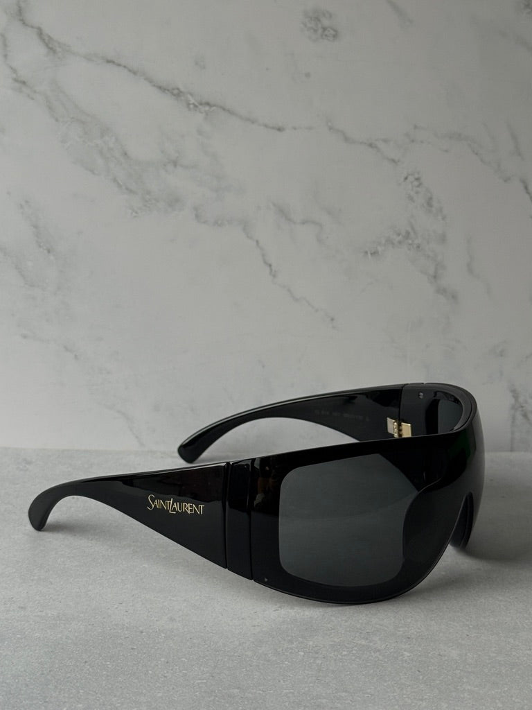 Black mask-style sunglasses with wraparound dark lenses and side logo, Saint Laurent