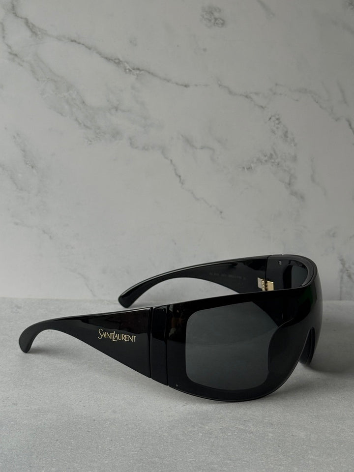 Black mask-style sunglasses with wraparound dark lenses and side logo, Saint Laurent
