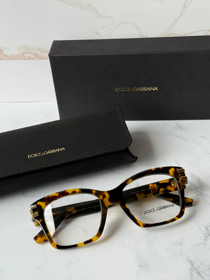 Tortoise-brown rectangular eyeglass frames with clear lenses and gold DG logo