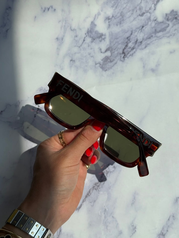 Square tortoiseshell sunglasses with green lenses and FENDI branding on frame
