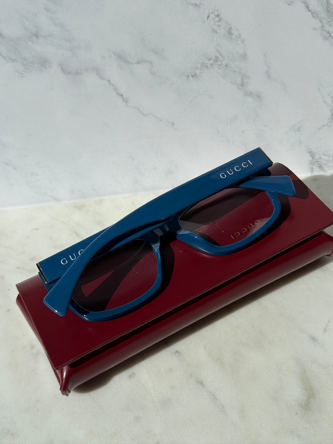 Gucci blue rectangular eyeglass frames, side view with GUCCI logo on arm