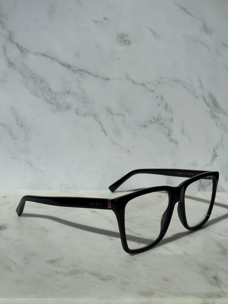 Black rectangular eyeglass frames with clear lenses and Gucci mark on temple