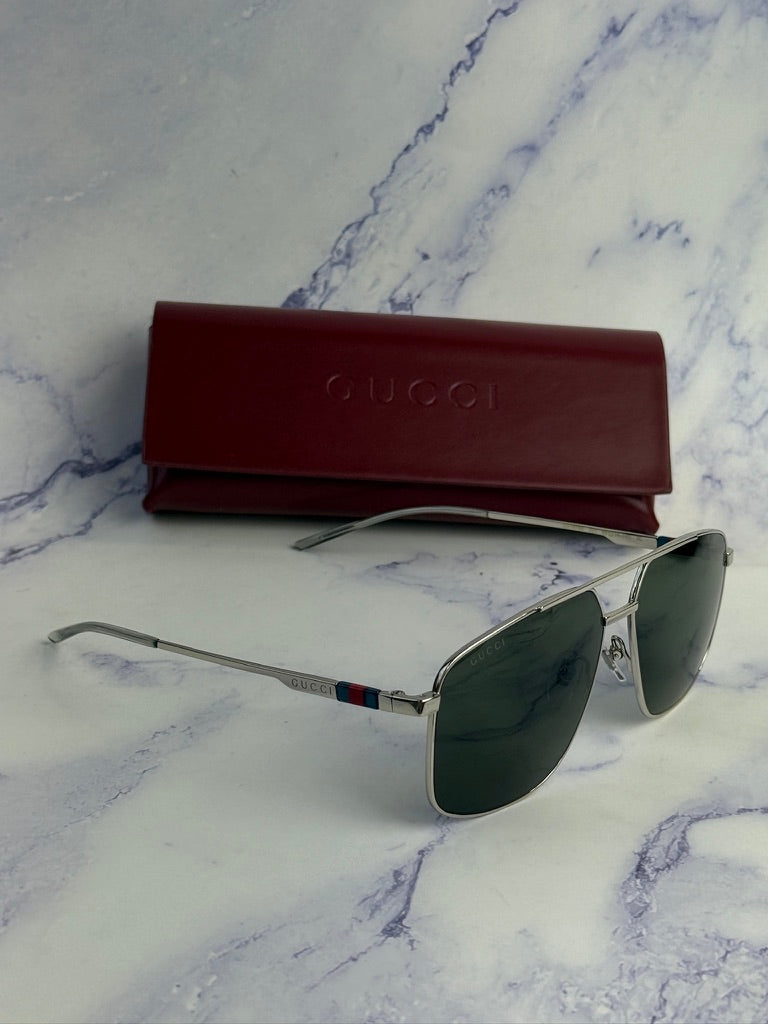 Silver metal aviator sunglasses with green lenses and red Gucci case