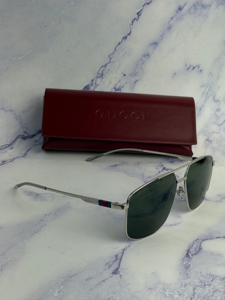 Silver metal aviator sunglasses with green lenses and red Gucci case