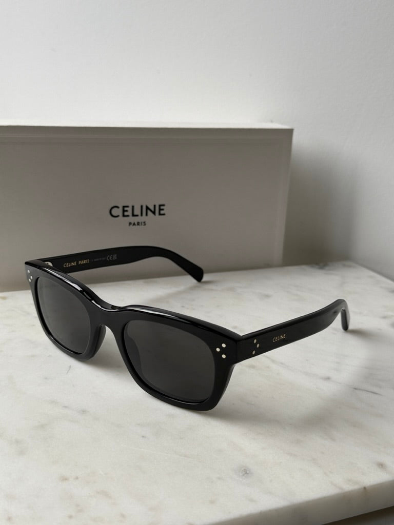 Black unisex square sunglasses with dark lenses, side perspective