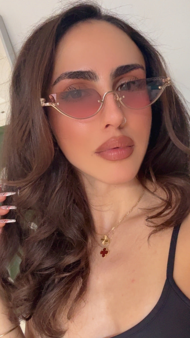 Gucci half-rim sunglasses on model, gold metal frame with pink lenses