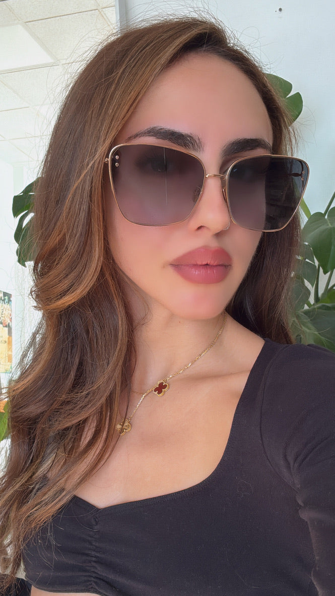 Dior gold-tone square sunglasses on model with dark grey gradient lenses
