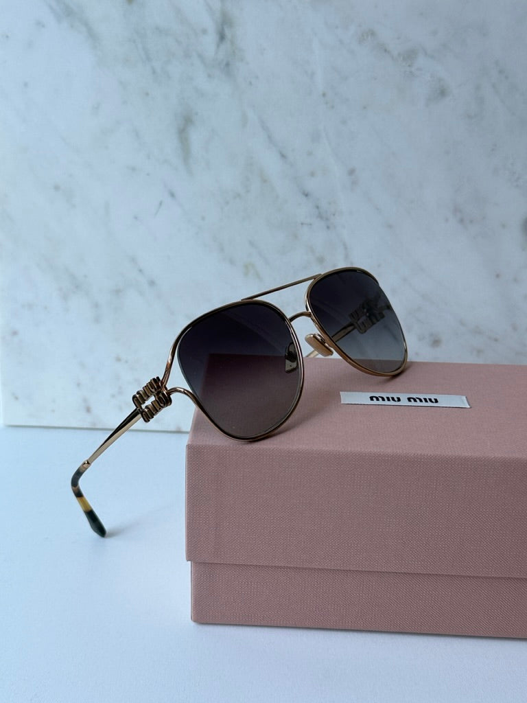 Miu Miu round aviator sunglasses with dark lenses, gold frame and bow temple