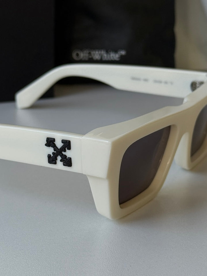 White sunglasses close-up with dark lenses and Off-White X logo on temple