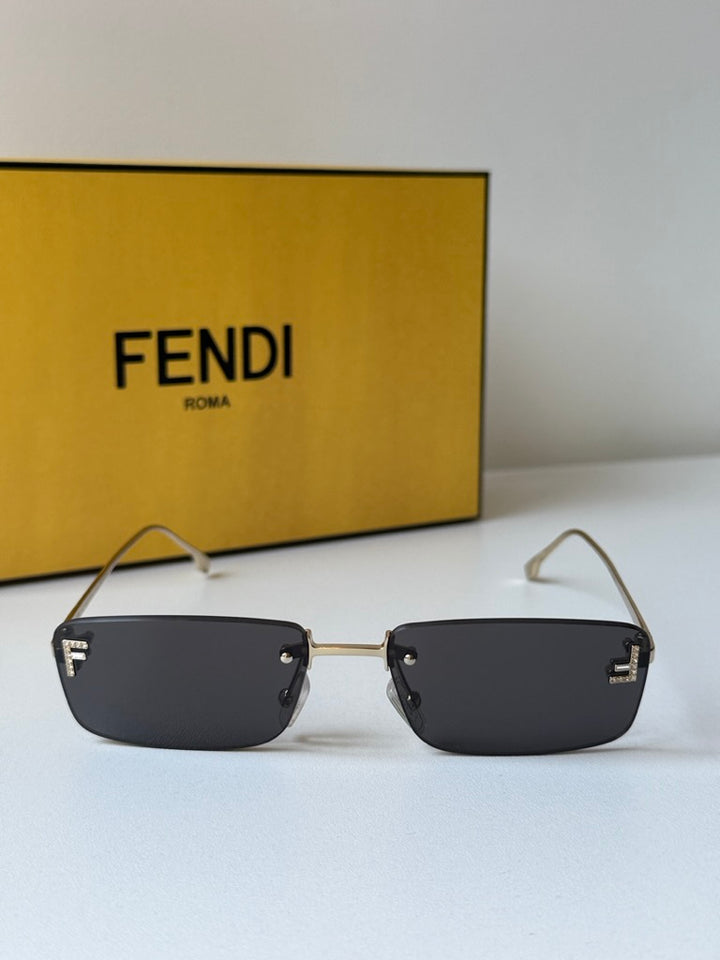 Rimless sunglasses with dark lenses and gold frame, flat square profile