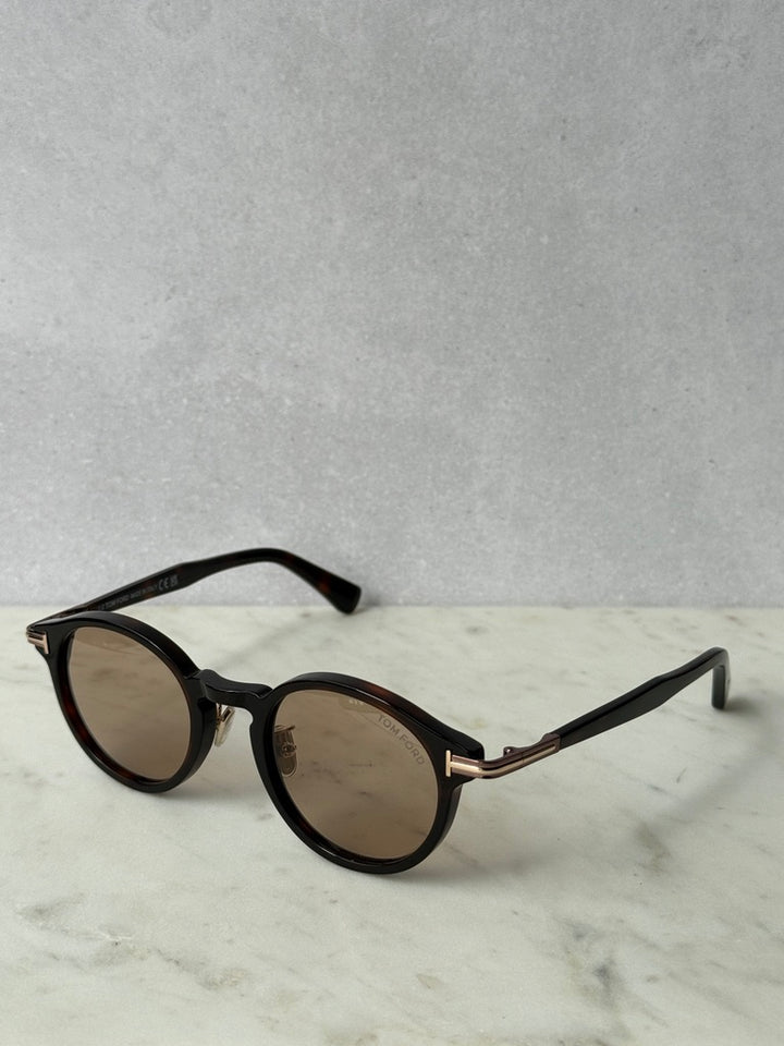Round sunglasses with dark-brown frames and slim temple arms