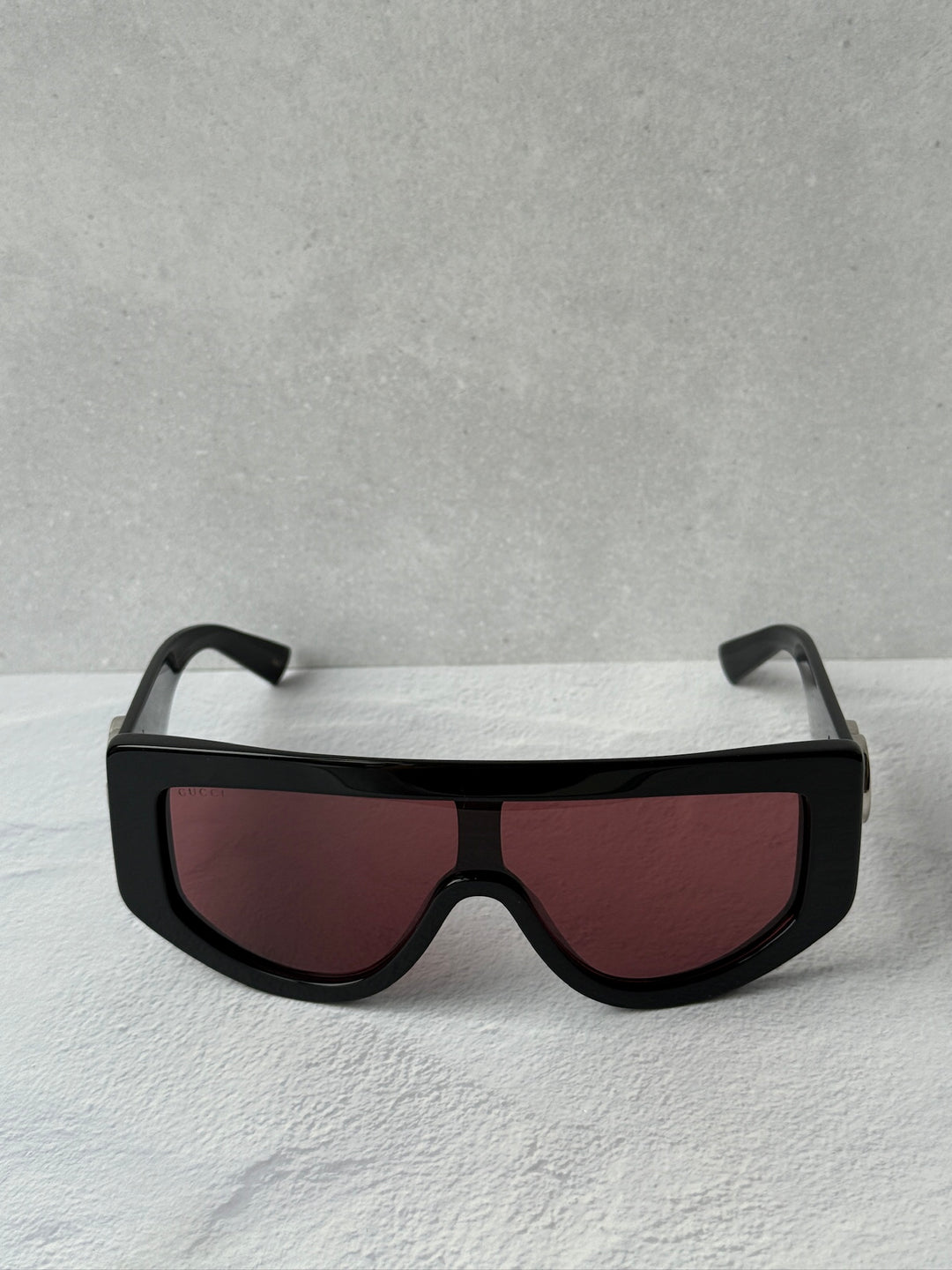 Oversized shield sunglasses with black frame and maroon tinted lenses