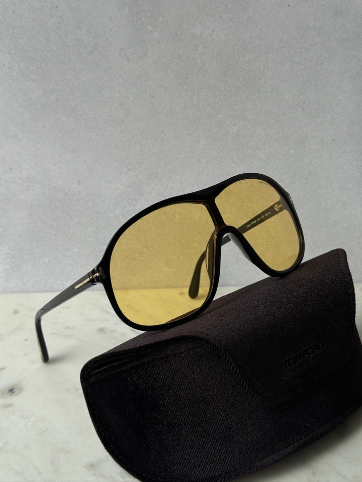 Black sunglasses with yellow lenses, shown with a black fabric carrying case