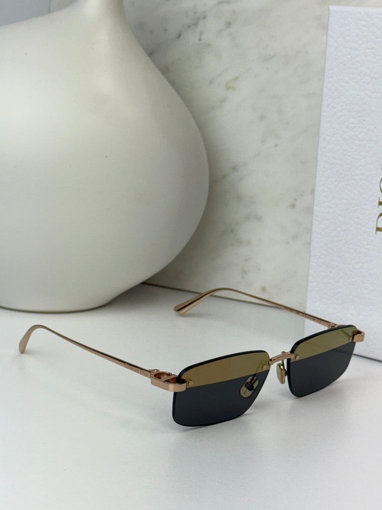 Rimless sunglasses with dark lenses and gold-tone temple arms, rimless design