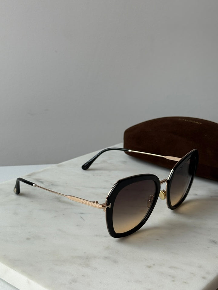 Black and gold Tom Ford sunglasses, angled side view with dark lenses
