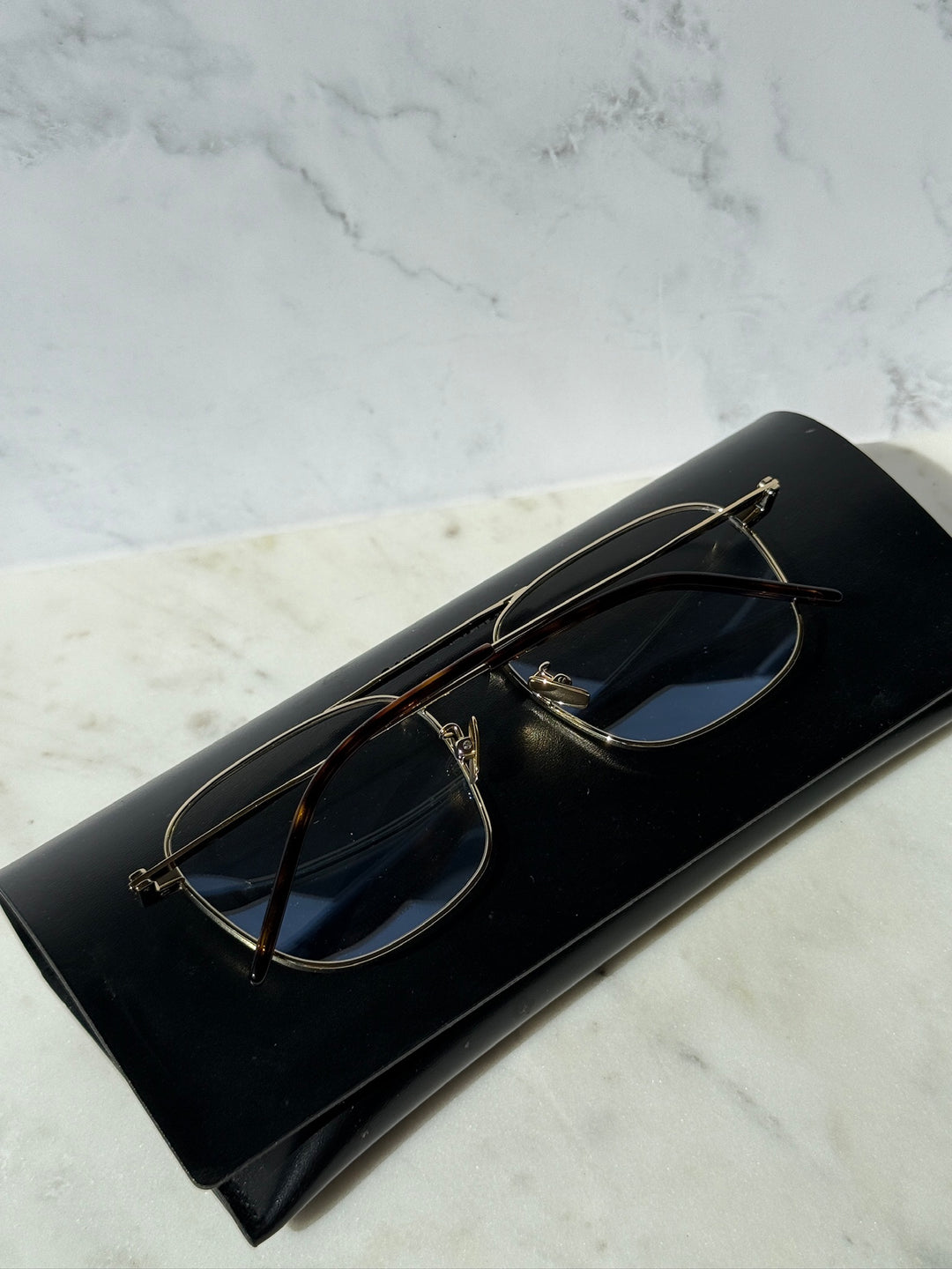 Gold aviator eyeglass frames with dark lenses and sleek metal bridge and temples.