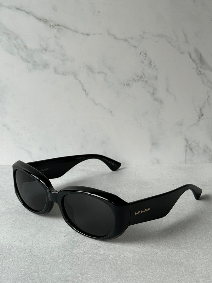 Black rounded sunglasses with dark lenses and logo on temple