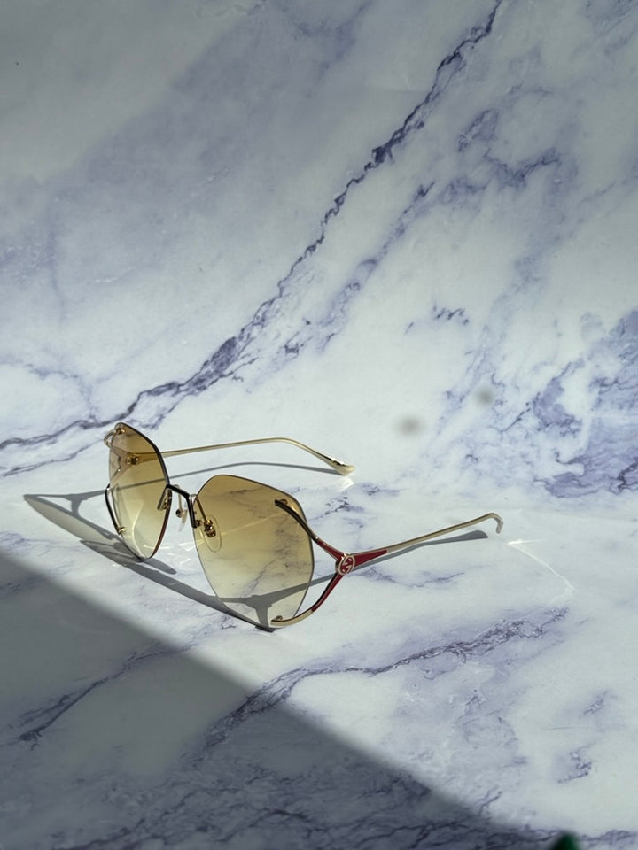 Gucci rimless sunglasses, angled view, gold frame with yellow lenses