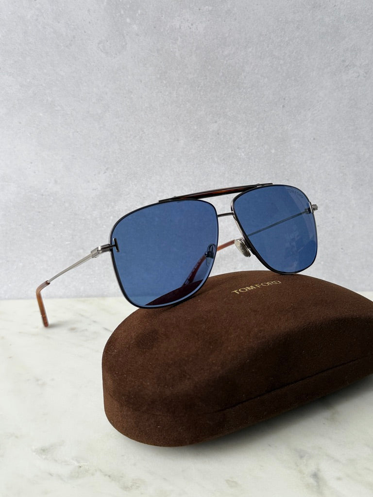 Ruthenium blue aviator sunglasses with mirrored lenses, side view on case