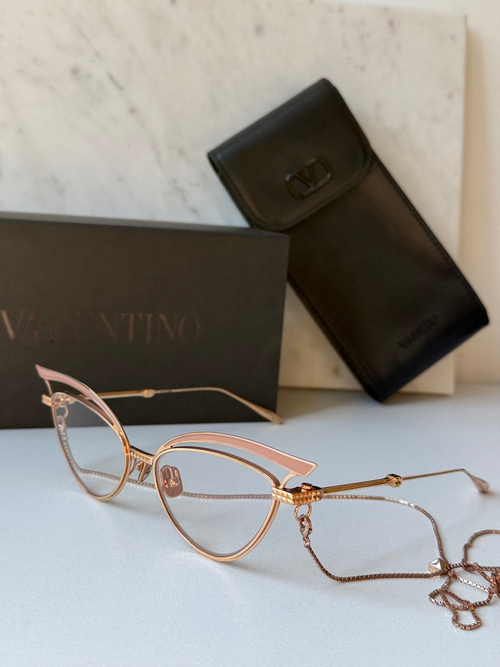 Gold-tone cat-eye eyeglass frames with beige lenses and attached chain