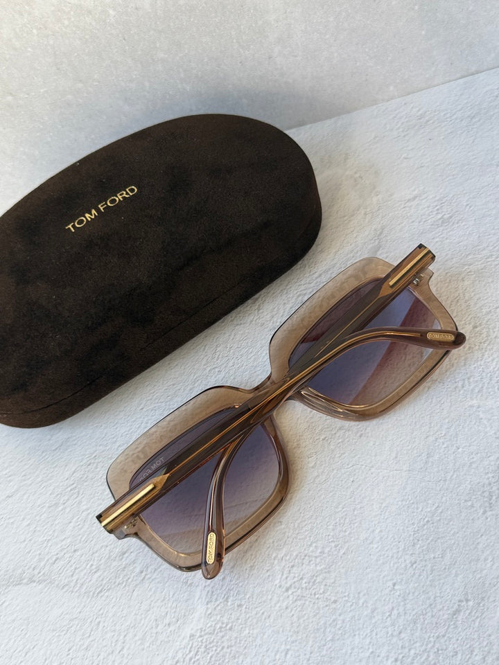 Transparent nude sunglasses with gold-tone hinges and tinted lenses, side view